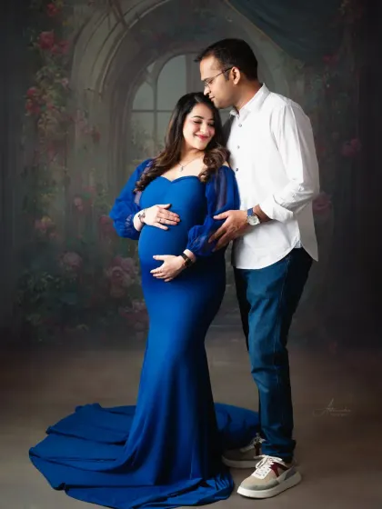 A sweet and romantic couple's portrait. The floral backdrop complements the royal blue gown, creating a look that feels both classic and enchanting.