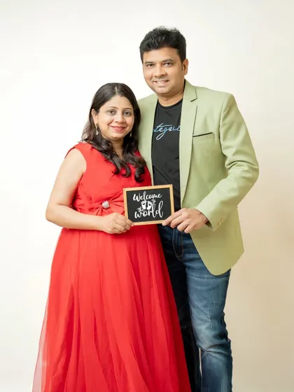 A fun announcement shot with the couple holding a "Welcome to the world" sign. It’s a simple and sweet way to share their happy news.
