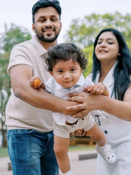 Parents lifting their baby boy, celebrating his first year. This kind of playful interaction creates the most natural and joyful family portraits.