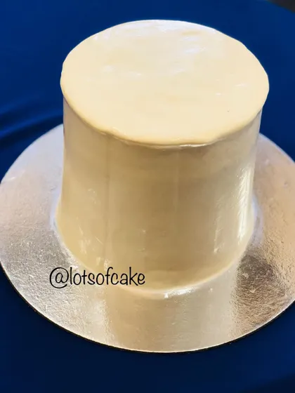 This is a tall red velvet cake with a perfectly smooth cream cheese frosting finish. Achieving sharp edges is a key skill I teach in my frosting and design workshop.