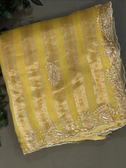 Another view of the yellow tissue stripes organza saree, showing the shimmer of the fabric.