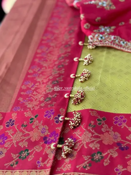 A close-up of the embroidered tassels on the back of the pink blouse.