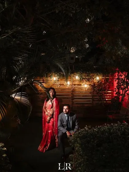 A dramatic, night-time portrait of a couple in a beautifully lit garden. We use creative lighting to set the mood and create a cinematic, romantic atmosphere.
