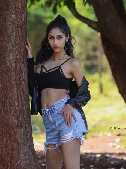 A relaxed lifestyle portrait taken in a park setting. Natural light and a casual pose like this help bring out the subject's genuine personality.