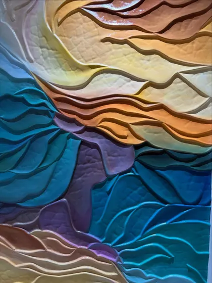 A close-up of the wave mural, allowing you to see the textures and the subtle blending of colors, from deep teals and purples to warm yellows and oranges.