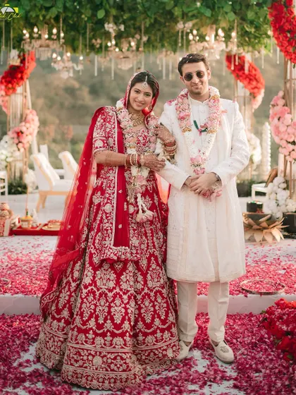 A classic portrait of the newlyweds at their mandap. Surrounded by a carpet of rose petals, this photo is a beautiful and traditional memory of their wedding day.