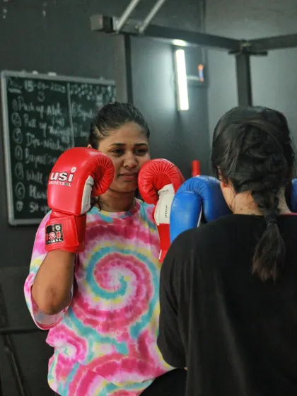 A friendly partner drill. One student smiles as she practices her defense, showing the positive environment of the gym.