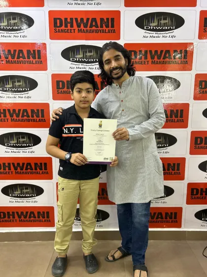 Our student with his teacher after successfully clearing his Trinity College London keyboard exam. Our faculty provides expert guidance for students aiming for formal music certification.