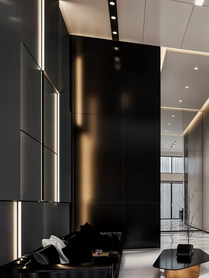 A moody seating area in the lobby, with black leather sofas set against tall, black wall panels with integrated lighting.