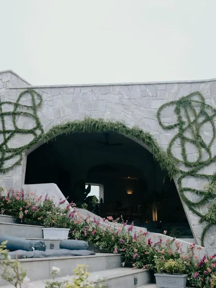We created this intricate pattern on the stone walls using fresh green foliage. It's a unique, organic detail that adds a layer of artistry and connects the architecture to the natural surroundings of Nandi Hills.