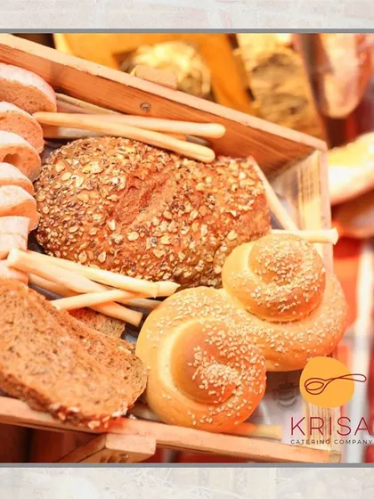 We believe in the importance of fresh bread. This display shows a variety of our house-baked breads, including multigrain loaves and sesame rolls, ready to accompany our buffet dishes.