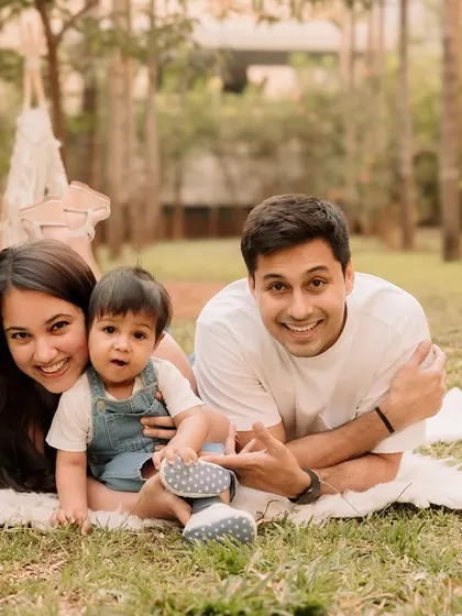 A happy family portrait, lying on the grass and smiling together.