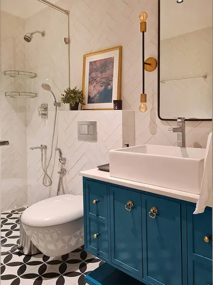Another angle of the master bathroom, highlighting the custom teal vanity. The open shelf at the base makes the piece feel lighter, while the mix of knobs and pulls adds an extra layer of custom detail.