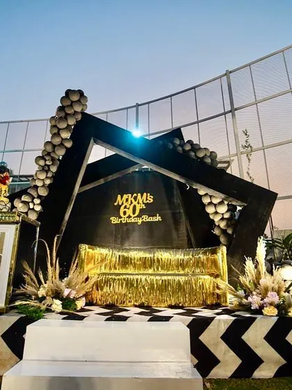 Celebrating a 60th birthday should be stylish and memorable. I created this modern, geometric stage with a bold black, white, and gold color scheme, complete with a custom chevron floor and elegant balloon garlands for a sophisticated birthday bash.
