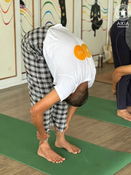 A close-up of a student in a deep forward fold, demonstrating the release and surrender that such poses can bring. This is a key aspect of the emotional and physical journey in our TTC.