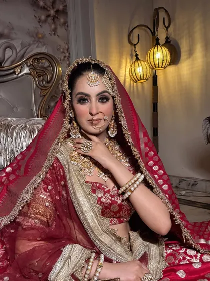 A beautiful portrait of a bride ready for her big day. This image captures the detailed eye makeup and the richness of her traditional red and gold attire.