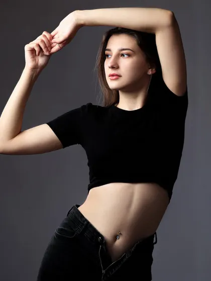 A simple and elegant pose in a black crop top. The focus is entirely on the model's form and expression, making it a great shot for a dance or fitness portfolio.