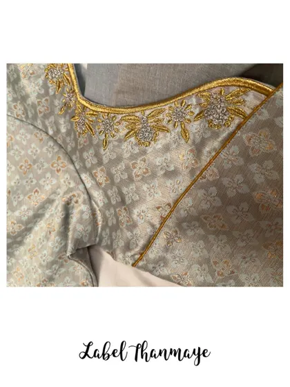 A detailed shot of the stone and thread work on the neckline of the grey blouse.