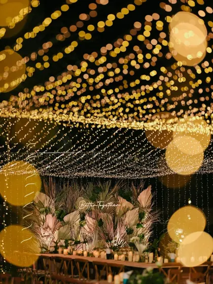 A magical, blurry shot of the welcome dinner setup, capturing the ambiance created by the canopy of lights.