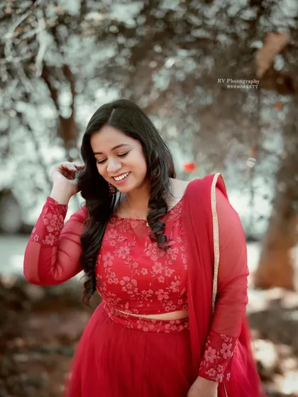 A close-up of the red Anarkali, showing the detailed embroidery on the bodice and the sheer sleeves.