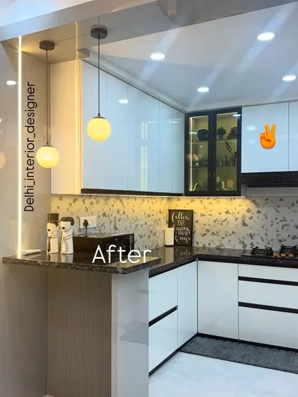 The final result. A stunning, modern kitchen with a white and black theme, terrazzo-style backsplash, and a breakfast counter, complete with pendant lights.