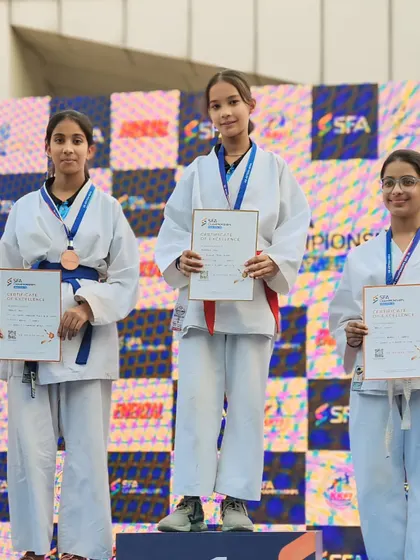 My female students showing their medals and certificates on the SFA podium. They are powerful examples of strength and skill.