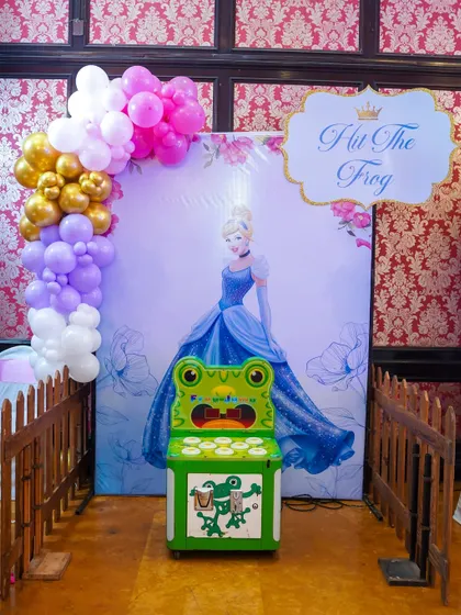 The classic 'Whac-A-Mole' style game, themed here as 'Hit The Frog' for a Disney Princess party with a Cinderella backdrop.