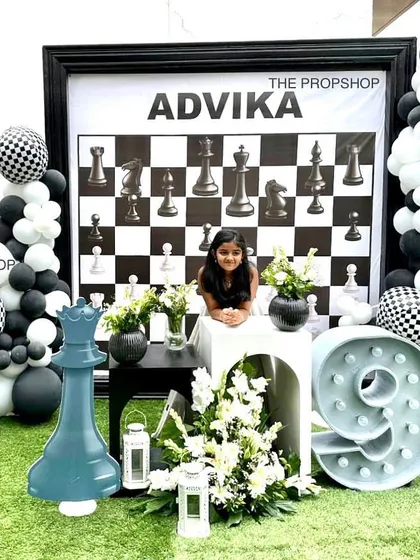 For a unique and sophisticated celebration, we designed this complete chess-themed party. The setup includes a custom checkerboard backdrop, giant chess piece props, and a themed marquee number for a truly memorable event.