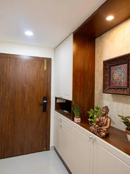The warm and welcoming foyer of Nisha and Arun's home. The design includes a custom shoe cabinet with a seating area and beautiful wooden accents.