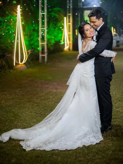 A romantic embrace on the wedding lawn. The bride's mermaid-style gown with its long train looks absolutely stunning.
