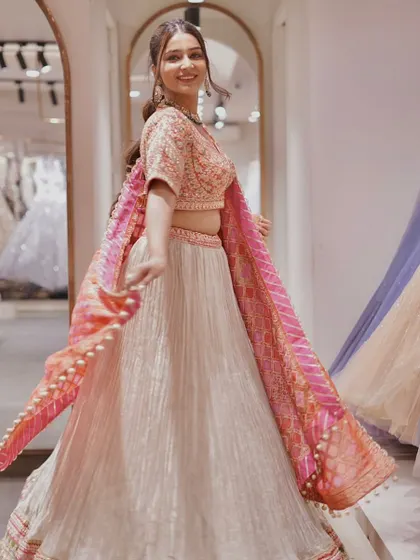 Colors of joy! This image captures the beautiful twirl of the pastel grey and pink lehenga, showing off its unique color combination and fun tassels.