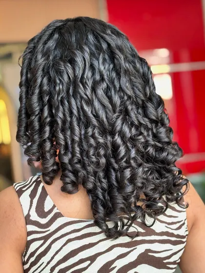 This is the result of a precision curly cut and proper hydration. Notice the individual curl clumps, the complete lack of frizz, and the healthy shine. We achieve this by cutting the hair dry, curl by curl, to create the perfect shape for your specific texture.