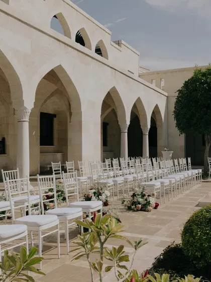 The ceremony setup at the Ismaili Centre, with clean white chairs and simple floral arrangements, creating a feeling of serene elegance.