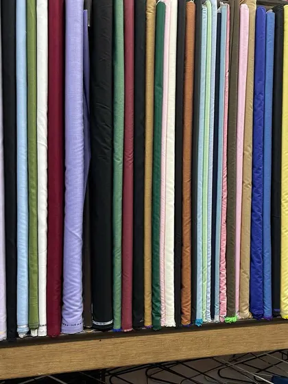 A selection of solid-colored fabrics, perfect for trousers, suits, or kurtas. I stock high-quality materials in every shade.