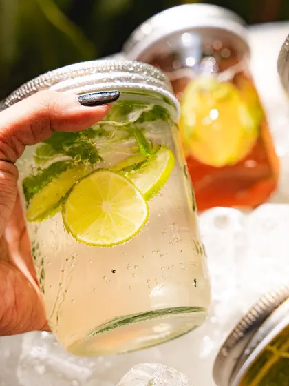 A hand holding our lime and mint soda, a classic and popular choice.