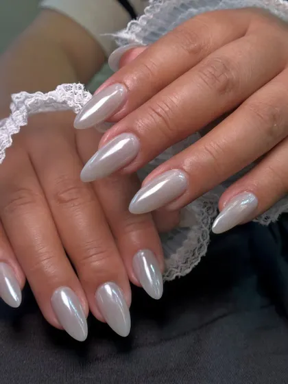 A close-up of the smooth, mirror-like surface of these chrome nails. This effect is achieved by buffing a special powder over a gel base.