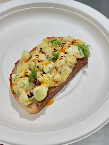 A close-up of a tasty egg salad toast, one of the many healthy options available at our cafe to help you recover right.