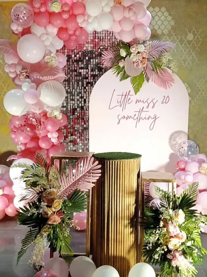 The full view of the "Quarter Life Calling" party decor, with elegant floral arrangements, pedestals, and a stunning balloon garland.