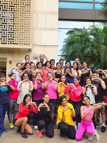 A group photo from a World Wellness Weekend event at The Ritz-Carlton, Bangalore. The heart signs say it all: these sessions are about building a positive, connected community through dance and fitness.