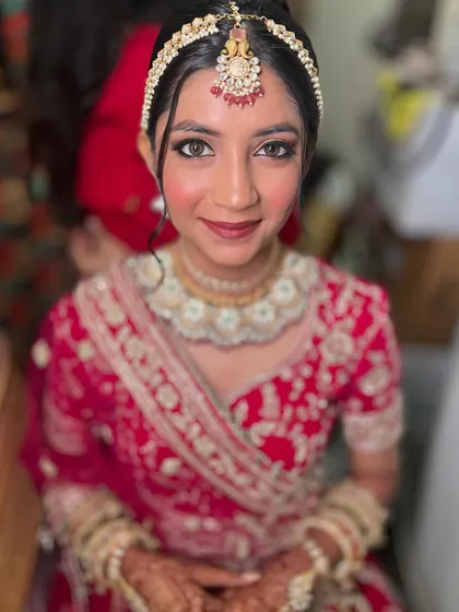 A straight on portrait of Jinal, looking like a doll. Her skin looks luminous and her eyes are the star of the show.