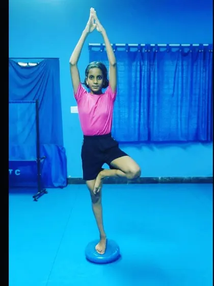 Balance is critical in table tennis. A young paddler practices the tree pose on a balance disc, an exercise that significantly improves stability and concentration.