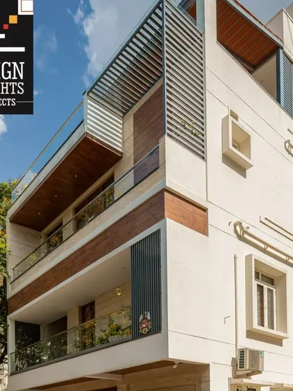 This completed project features wide balconies with wooden soffits and glass railings, creating a warm and modern aesthetic. The design prioritizes open, light-filled spaces.
