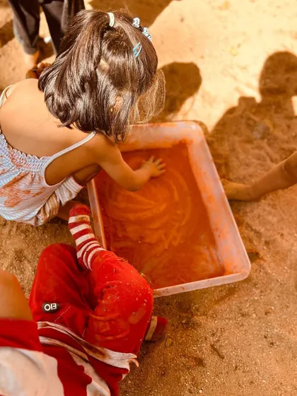 A child creates patterns in a tray of colored paste during our Holi activities. We provide multiple ways for children to engage with a theme, ensuring that every child can find a way to connect and express themselves.