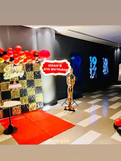 A fun Bollywood-themed 8th birthday party. The entrance features a red carpet, a checkered shimmer wall, and an Oscar statue prop.