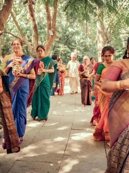 The bride's procession, with female family members carrying traditional offerings. A beautiful candid shot capturing an important part of the wedding tradition.