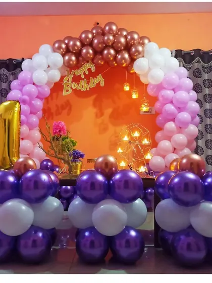 A beautiful setup for a first birthday party at home. We used a semi-arch of pink, white, and chrome balloons, a large gold foil number "1", and candle-lit accents to create a warm and inviting celebration space.