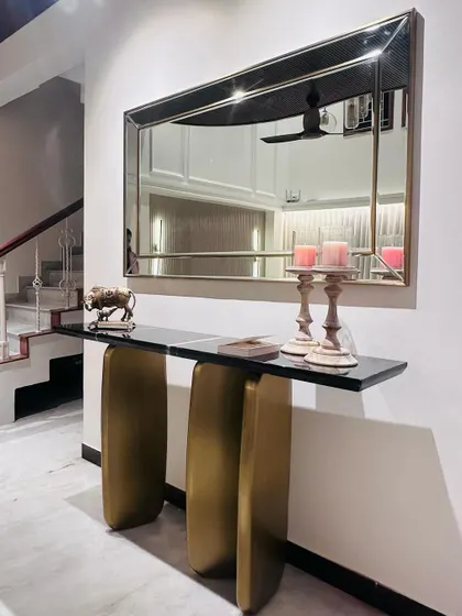 This image shows the complete console and mirror set in its foyer setting. The sculptural PVD gold base of the table creates an elegant and welcoming entryway statement.