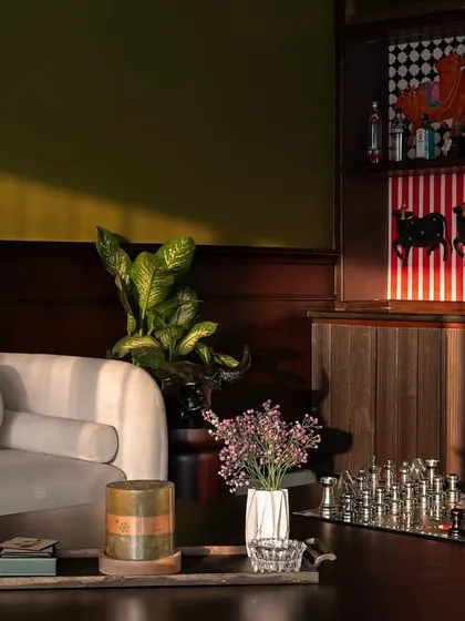 Here, the afternoon light catches the rich teak wood panelling and the unique art pieces in the bar cabinet. I designed this corner to be a cozy spot for evening relaxation, complete with a chess set and curated decor.
