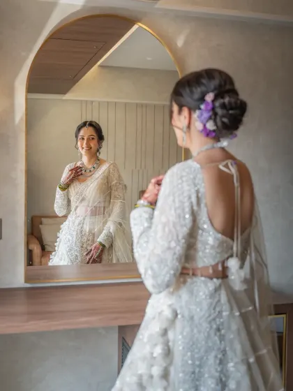 A beautiful getting-ready shot of the bride admiring her reflection. These quiet, happy moments before the ceremony are so special to capture.