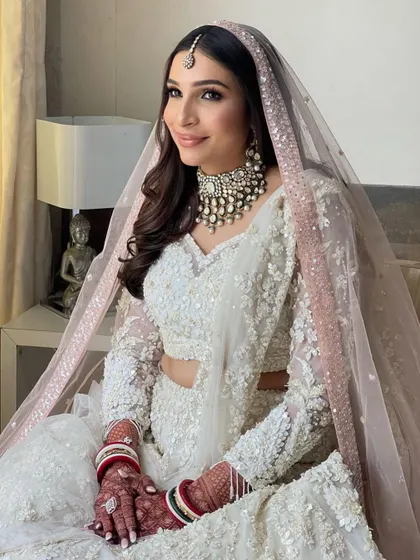 The soft waves and pink-toned dupatta create a dreamy and ethereal bridal look.